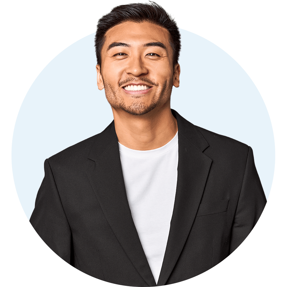 Man wearing a black suit jacket smiling at the camera.
